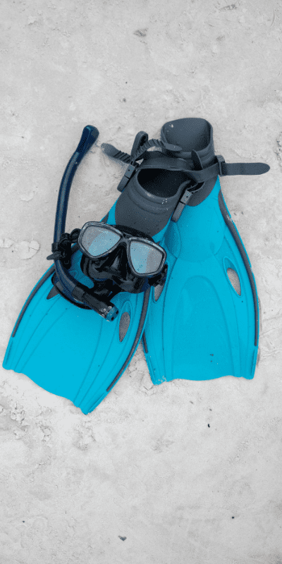 Swimming goggles and flaps on sand