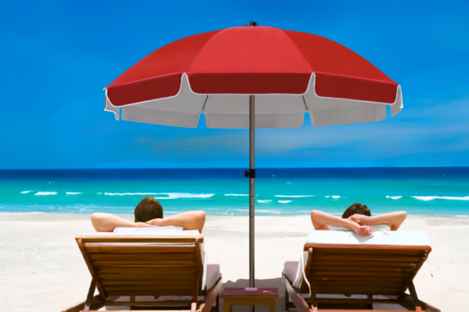 Red beach umbrella providing shade to two individuals